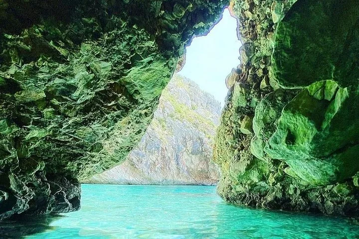 Blick aus einer Meereshöhle hinaus auf felsige Klippen
